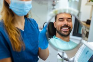 dental hygienist showing patient smile in mirror